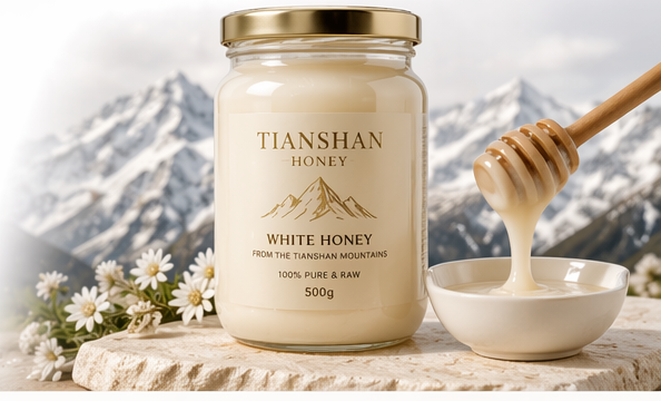 Jar of white honey with bowl and honey dipper